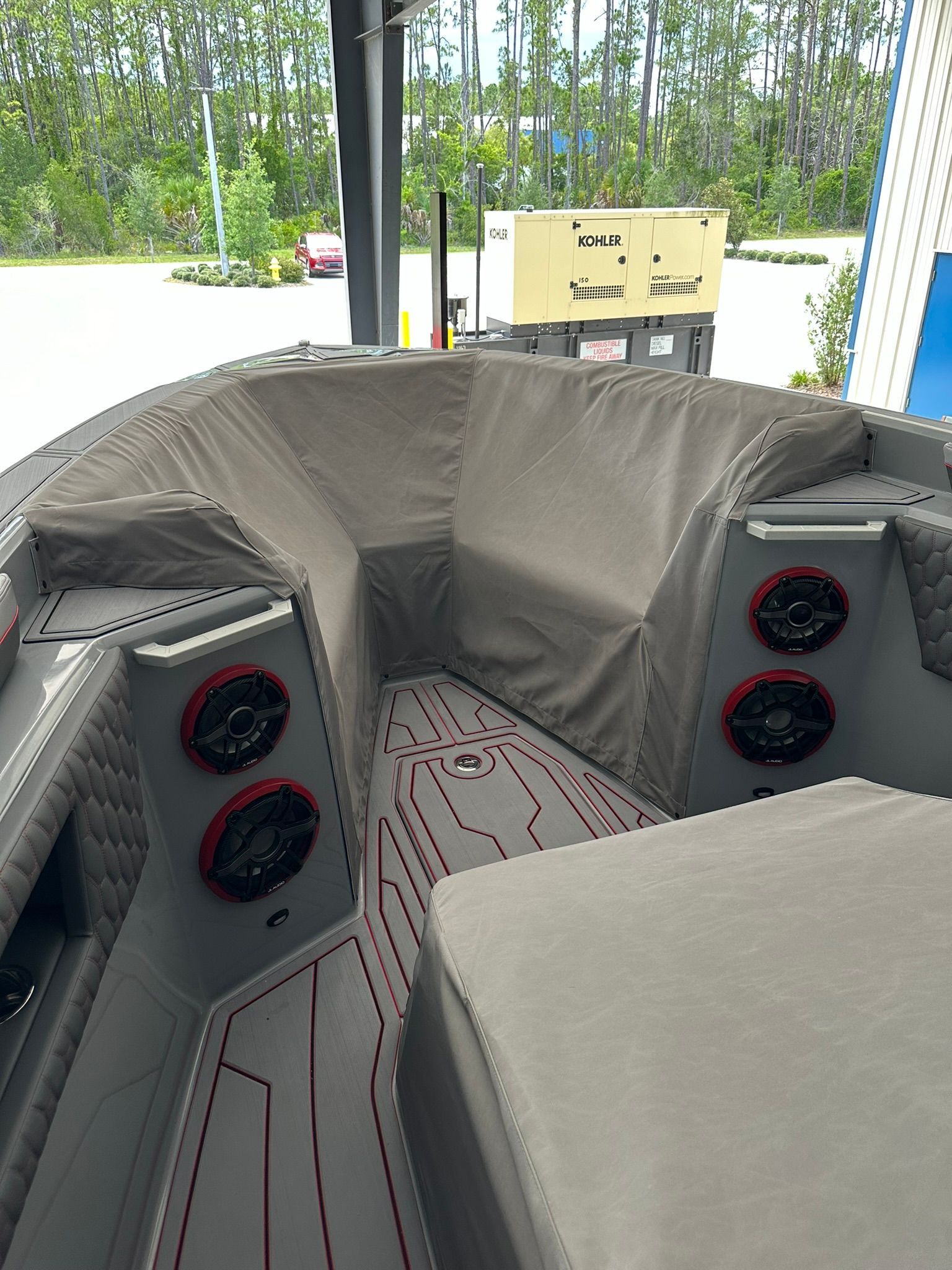 The inside of a boat with a couch and speakers.