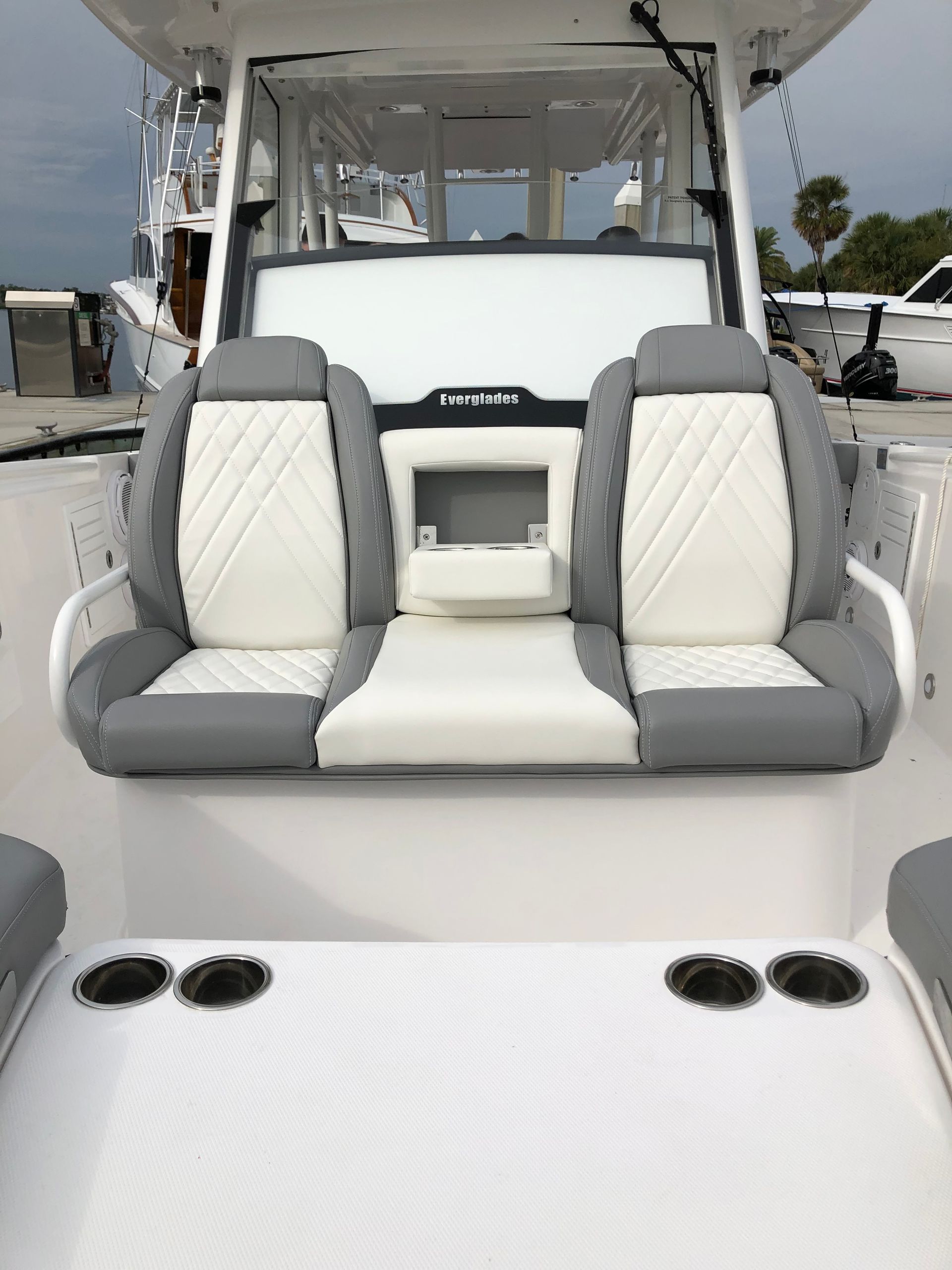 The front of a white boat with gray and white seats.