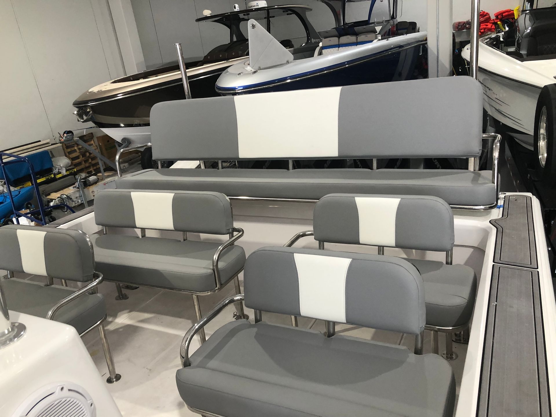 A boat with gray and white seats is parked in a garage.
