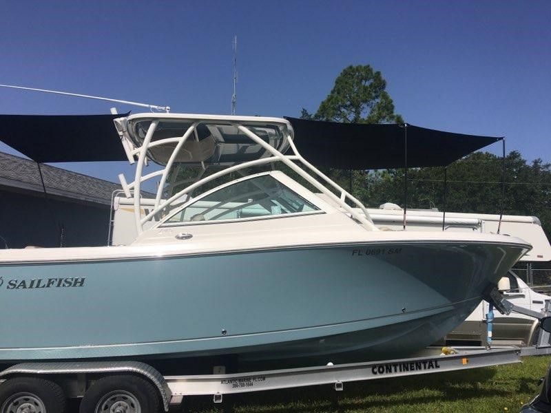 A sailfish boat is parked on a trailer on a sunny day