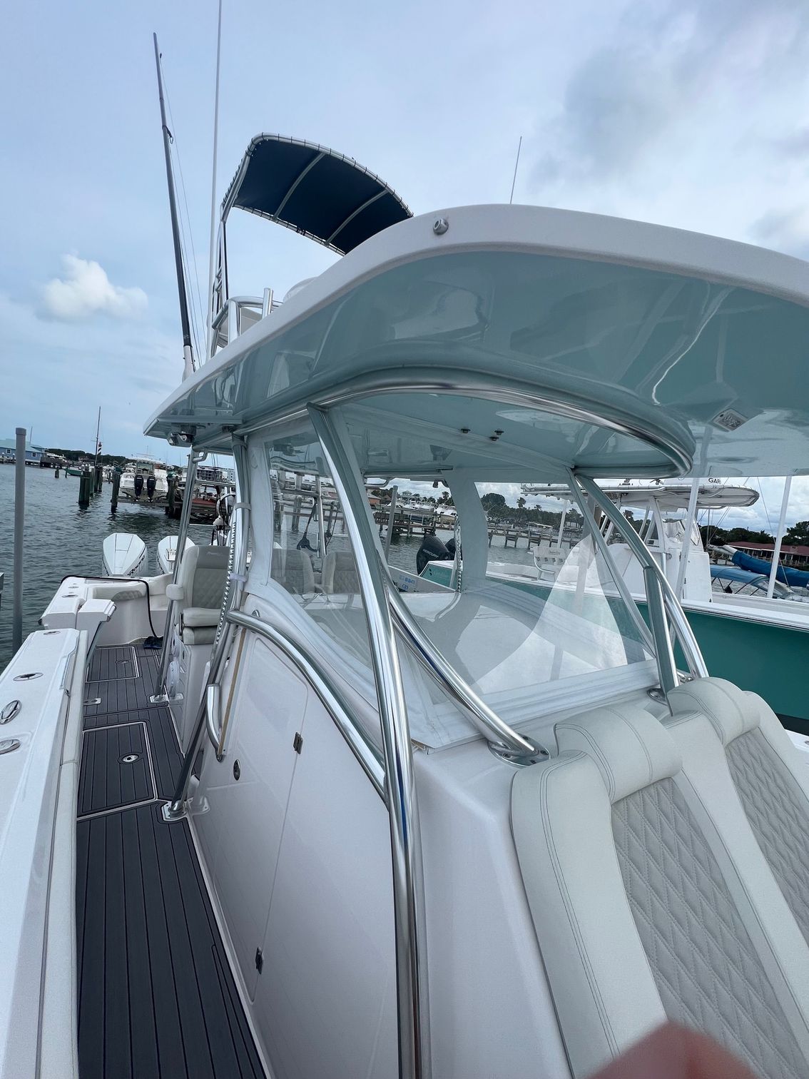 A white boat is docked at a dock in the water.