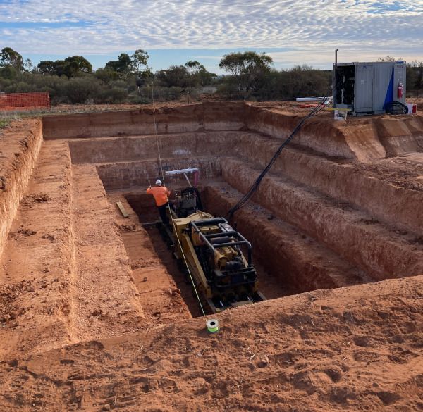 A large hole in the ground with a bulldozer in it