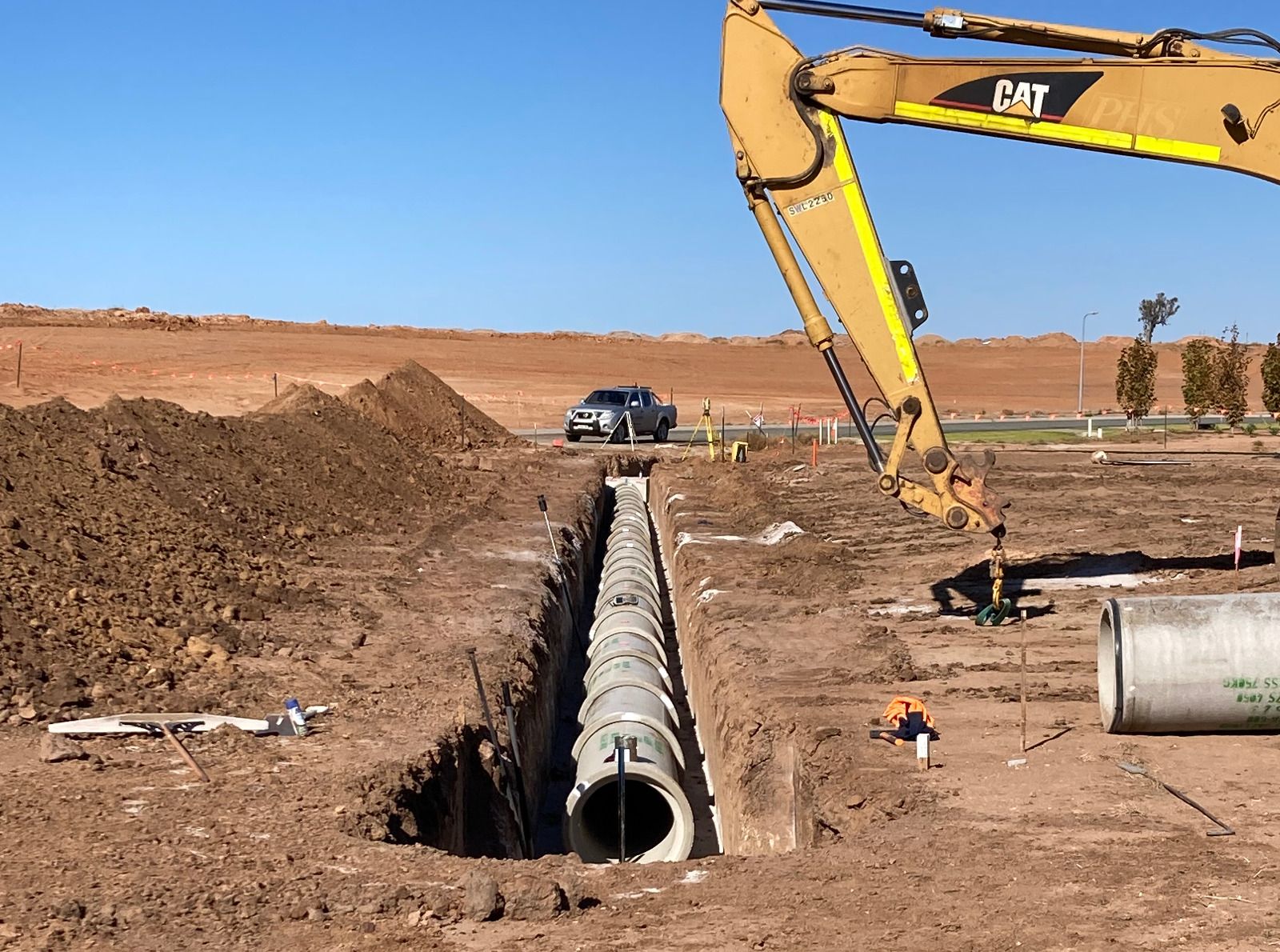 A cat excavator is digging a hole in the ground