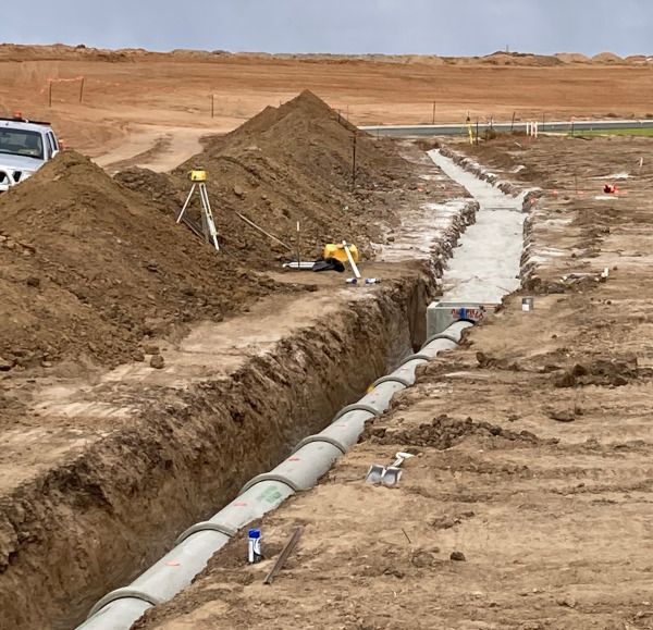 A construction site with a lot of dirt and pipes
