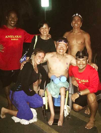 A group of people posing for a picture with one wearing a shirt that says anekaka