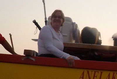 A woman sits in a boat with the name anel ak on the side