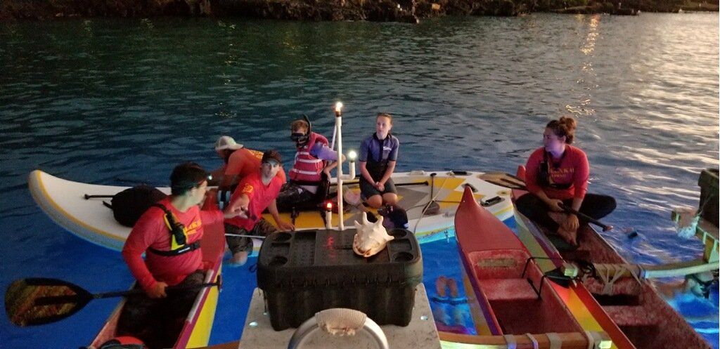 A group of people are sitting on a boat in the water.