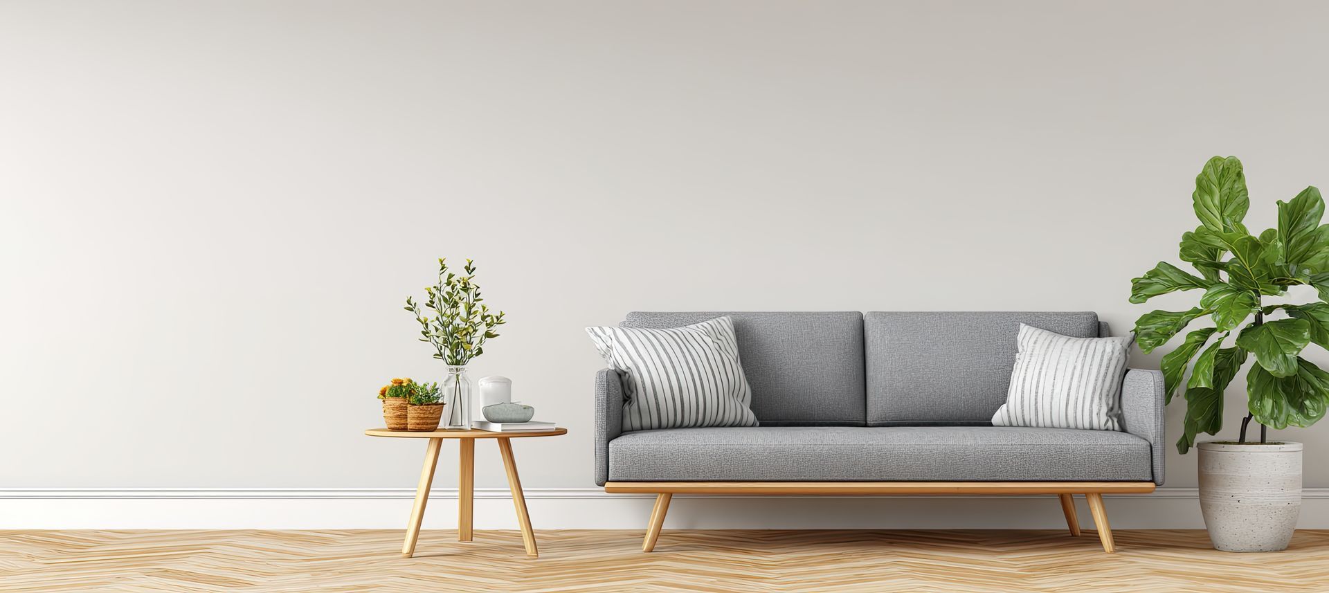 Minimalist living room with gray sofa, side table, and green potted plants on a white wall backdrop