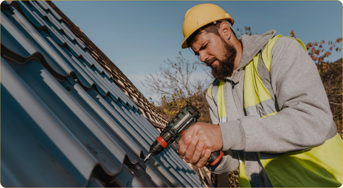 A man is working on a roof with a drill.