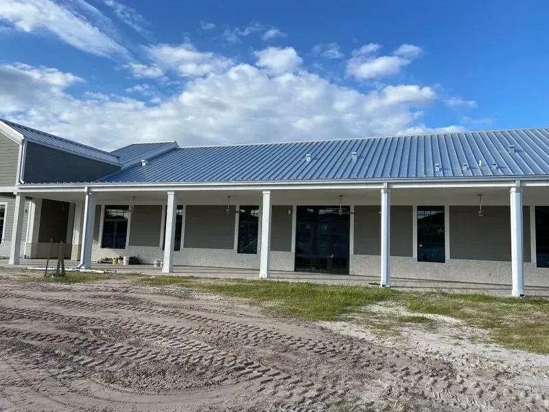 A large house with a metal roof and a porch.