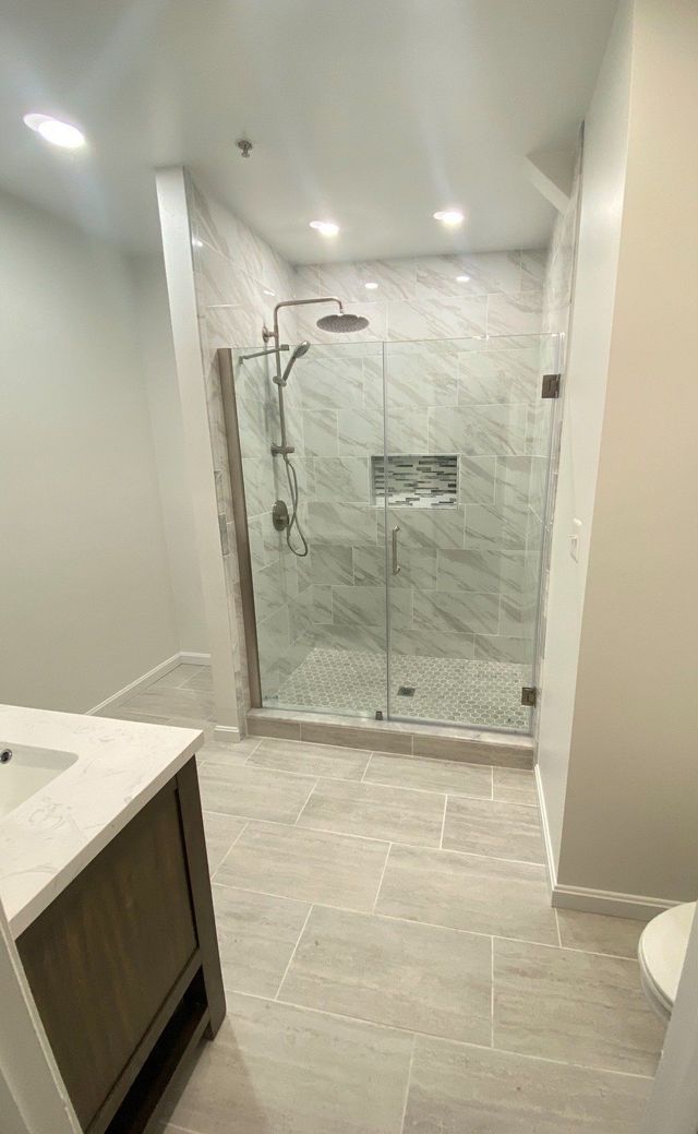 Frameless glass shower enclosure with tile floor, a Handyman on Demand bathroom remodel