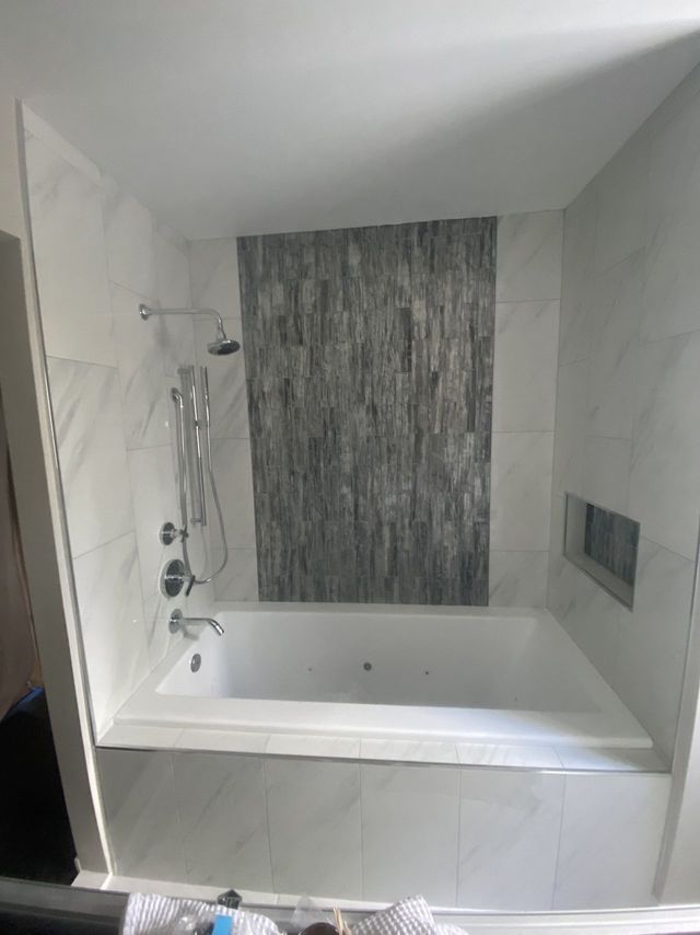 Tub surround with a stone-look accent panel, a Handyman on Demand bathroom remodel