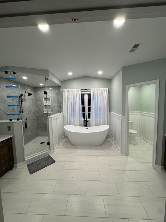 Soaking tub under the window beside a frameless glass shower, a Handyman on Demand bathroom remodel