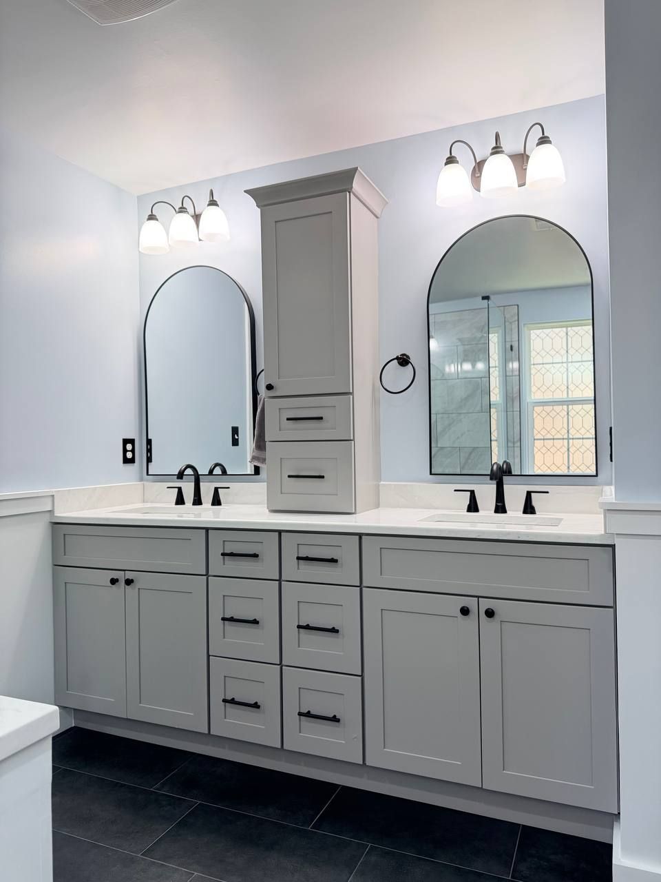 Professional bathroom remodel in Baltimore County MD featuring double vanity, gray shaker cabinets, white quartz countertop, and arched mirrors by Handyman on Demand