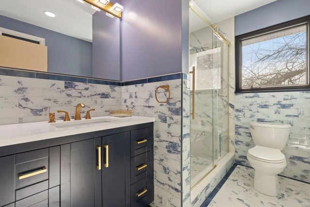 Navy vanity, glass shower and blue marble tile, a Handyman on Demand bathroom remodel