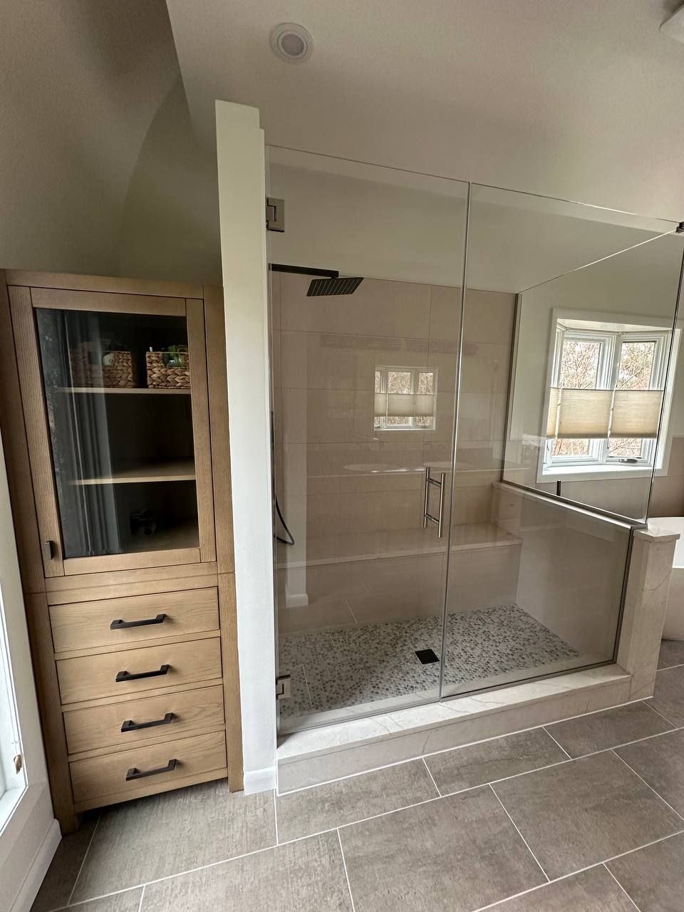 Licensed bathroom remodeling contractor in Baltimore County MD — frameless glass shower enclosure, built-in linen cabinet, and pebble stone shower floor by Handyman on Demand