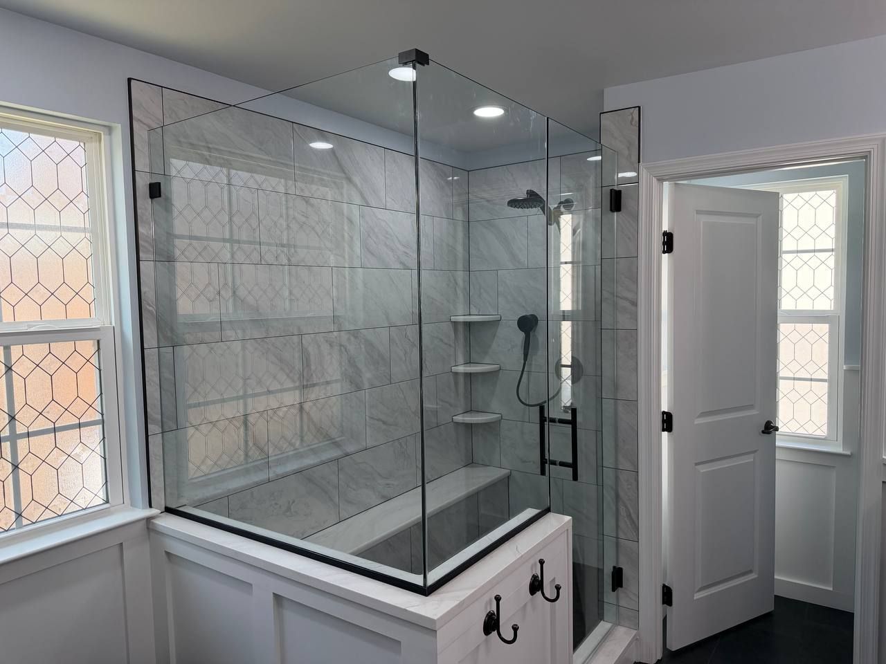 Professional bathroom renovation and remodel in Baltimore County Maryland featuring glass shower enclosure, marble tile, recessed lighting, and matte black hardware by Handyman on Demand