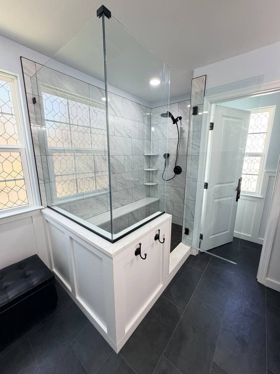 Custom bathroom remodel and renovation in Baltimore County MD with frameless glass shower, wainscoting knee wall, marble tile surround, and matte black hardware by Handyman on Demand