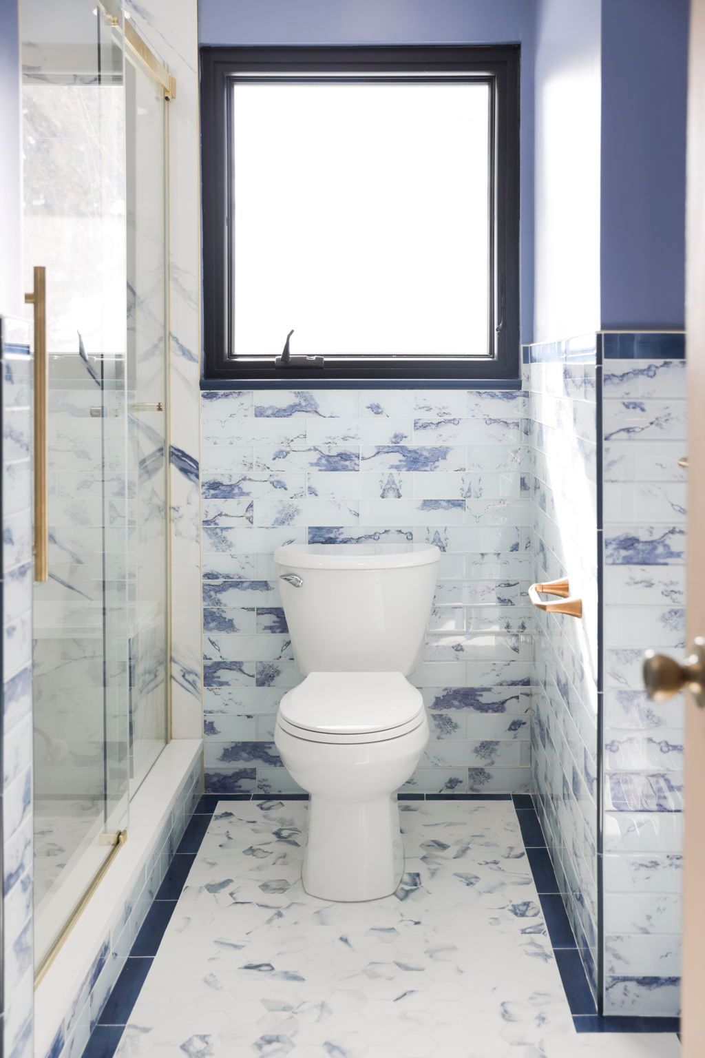 Full bathroom remodel overview with vanity, walk-in shower, toilet, and marble tile by professional remodeling contractor Handyman on Demand serving Baltimore County MD