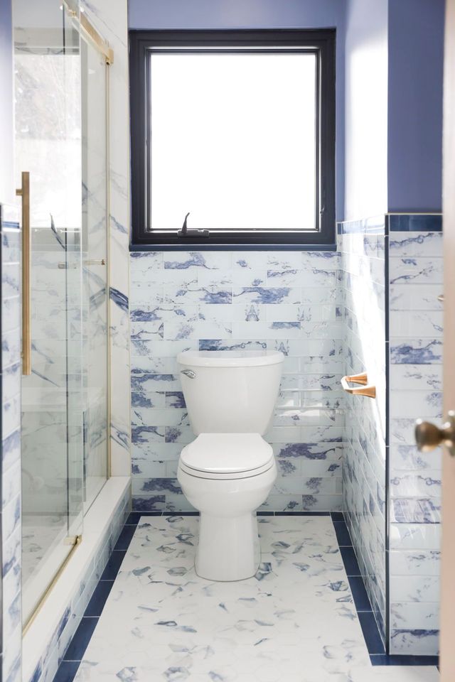 Marble-tile bathroom with glass shower and new toilet, a Handyman on Demand bathroom remodel