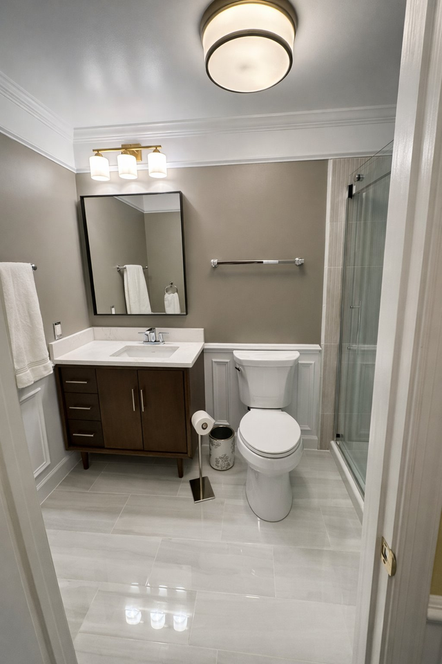 Walnut vanity, wainscoting and glass shower, a Handyman on Demand bathroom remodel
