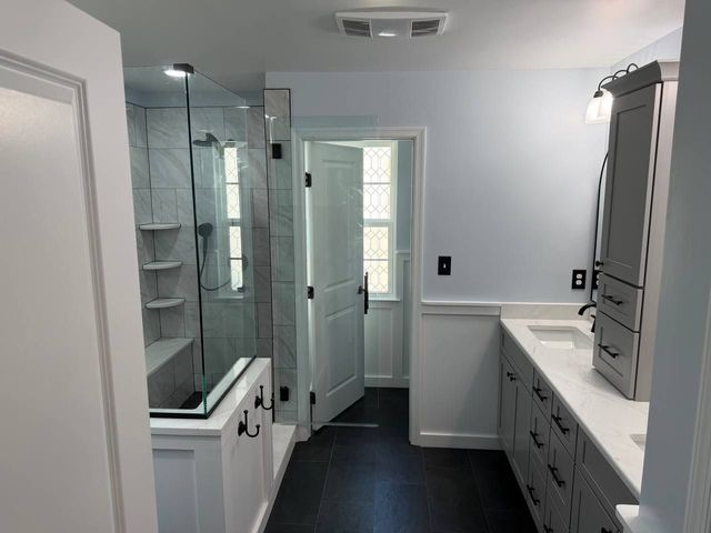 Marble-look shower, double vanity and dark slate floor, a Handyman on Demand bathroom remodel