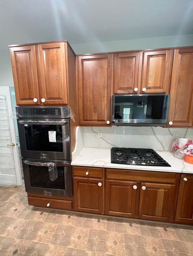 Cherry cabinets with double wall oven and gas cooktop, a Handyman on Demand kitchen remodel