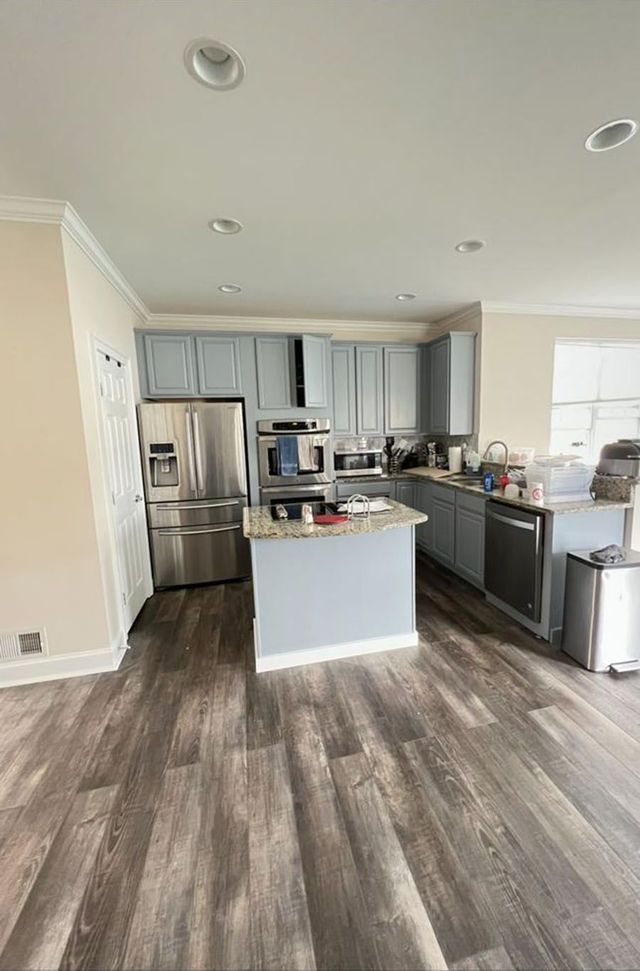 Open kitchen with gray island and plank flooring, a Handyman on Demand kitchen remodel