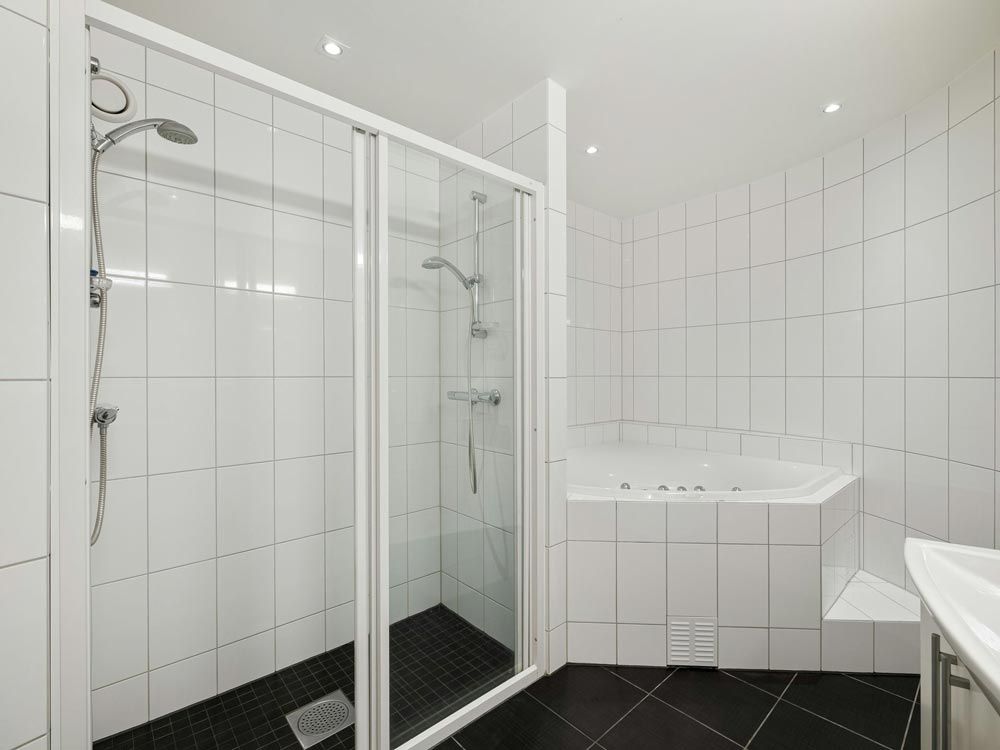 Bright white bathroom with glass shower enclosure