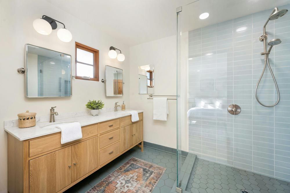 Bathroom with a light wood vanity, two mirrors