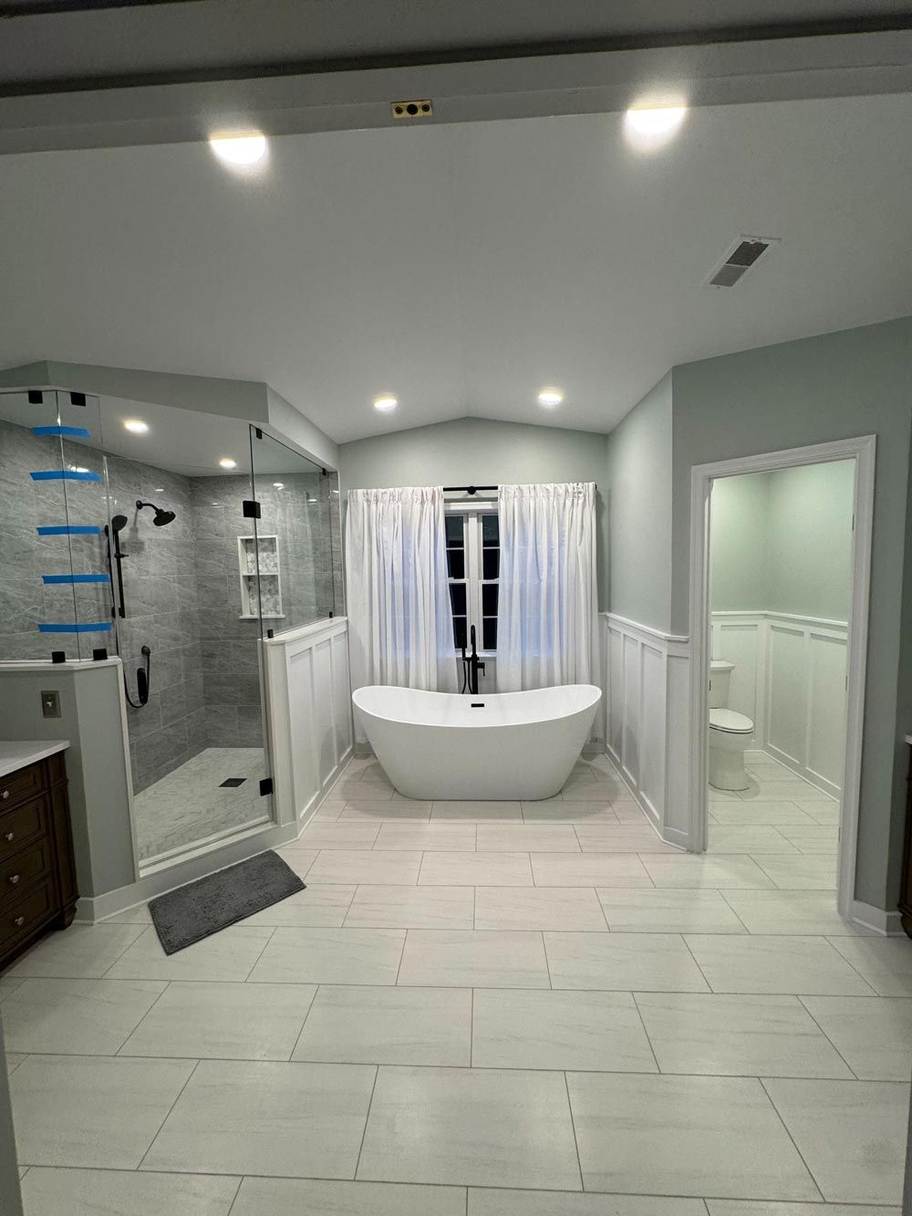 Spacious, light-blue and white bathroom with a modern freestanding tub