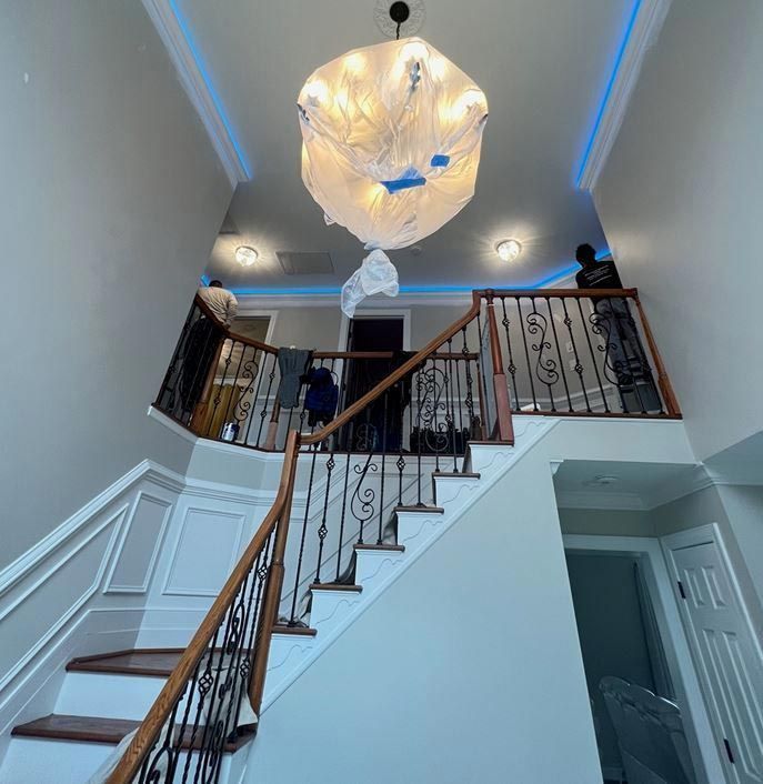 A two-story entryway with a staircase, chandelier
