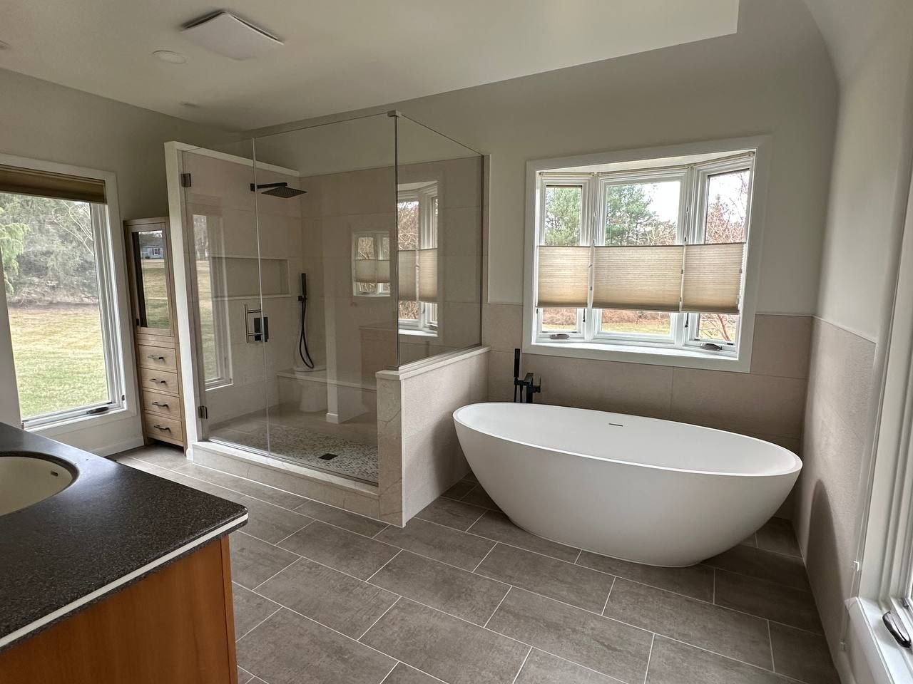 Luxury bathroom renovation and remodeling in Baltimore County Maryland featuring walk-in glass shower, freestanding soaking tub, and double vanity by Handyman on Demand
