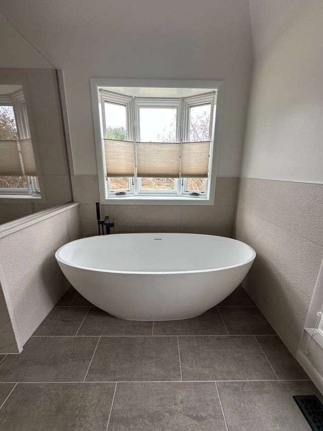 Freestanding soaking tub under a bay window