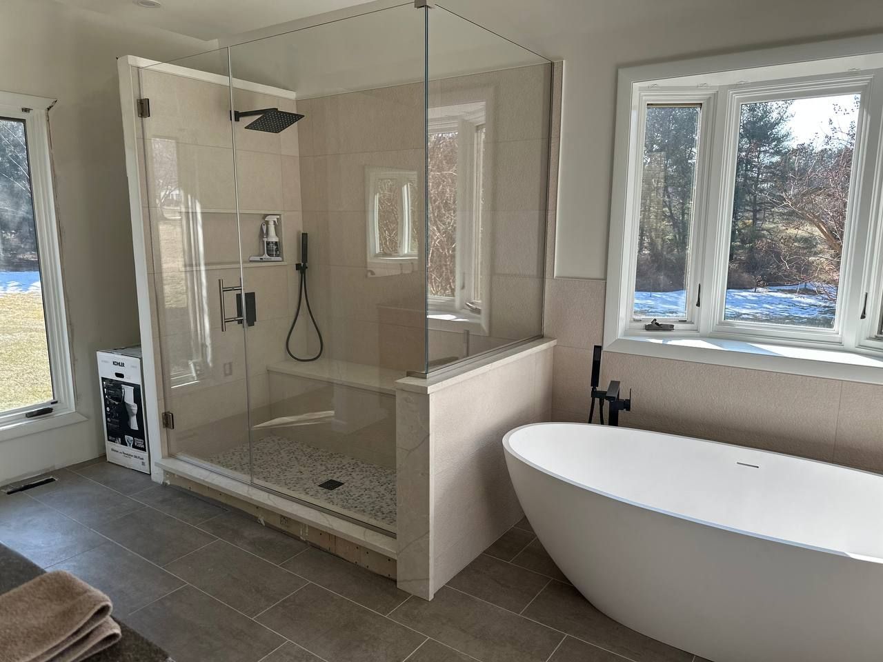 Completed master bathroom remodel with glass walk-in shower and freestanding soaking tub by Handyman On Demand