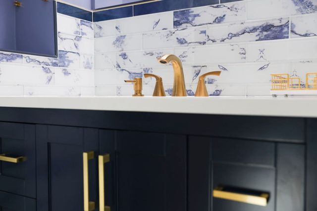 Navy vanity gold faucet blue marble backsplash bathroom in Silver Spring, MD