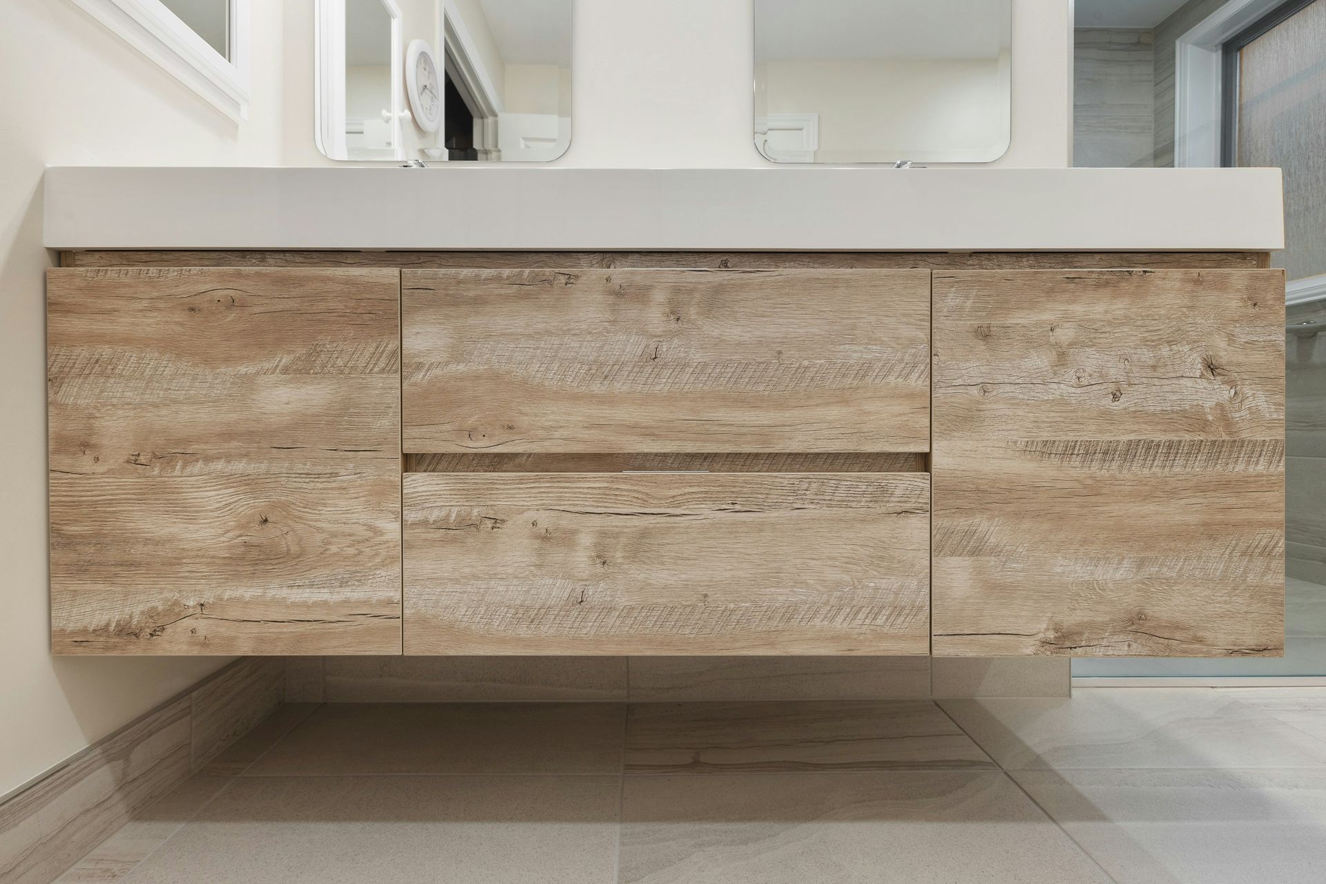 Floating bathroom vanity with travertine-style doors and a white countertop