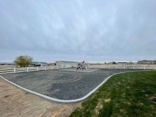 A backyard with a gravel play area, a concrete border.