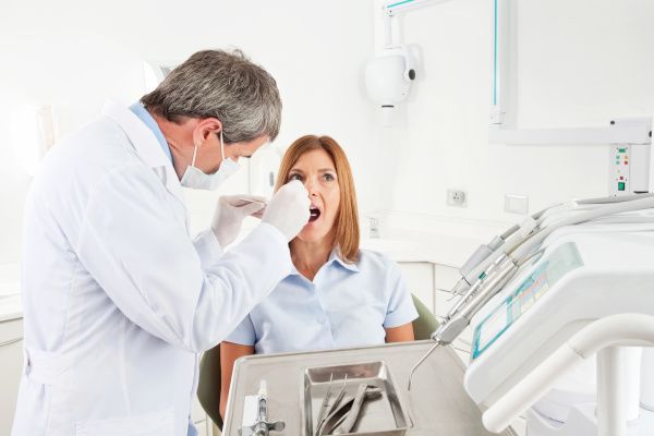 Zahnarzt im Notdienst behandelt eine Patientin