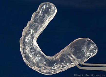 Sog. Aufbiss-Schiene, die Störkontakte zwischen den Zähnen ausgleicht und damit Zähneknirschen und -pressen verhindert.