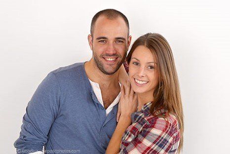Lächelnder Mann und Frau mit festen Zähnen durch Implantate in Berlin