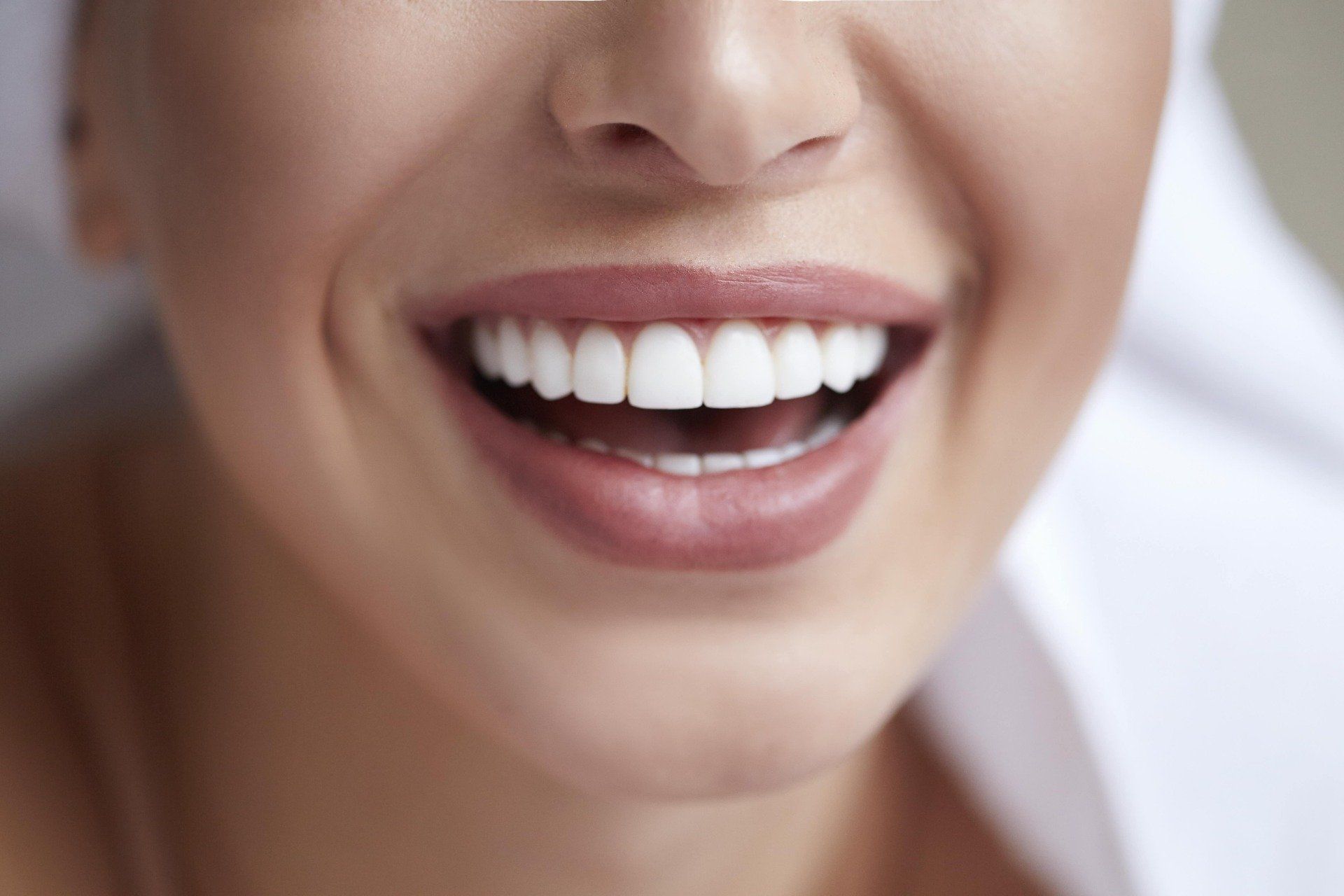 Lächelnde Frau mit weißen Zähnen nach Bleaching