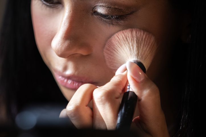 Mani che sistemano scatole e flaconi di medicinali in una scatola di spedizione bianca isolata.