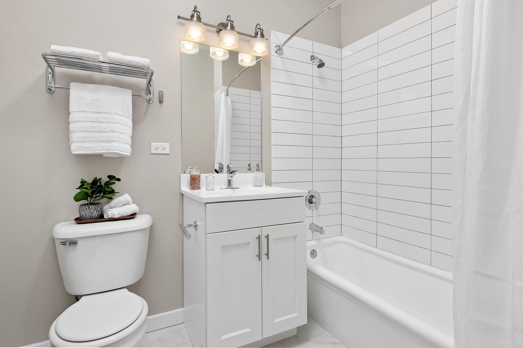 a white bathroom with a white toilet and a tub