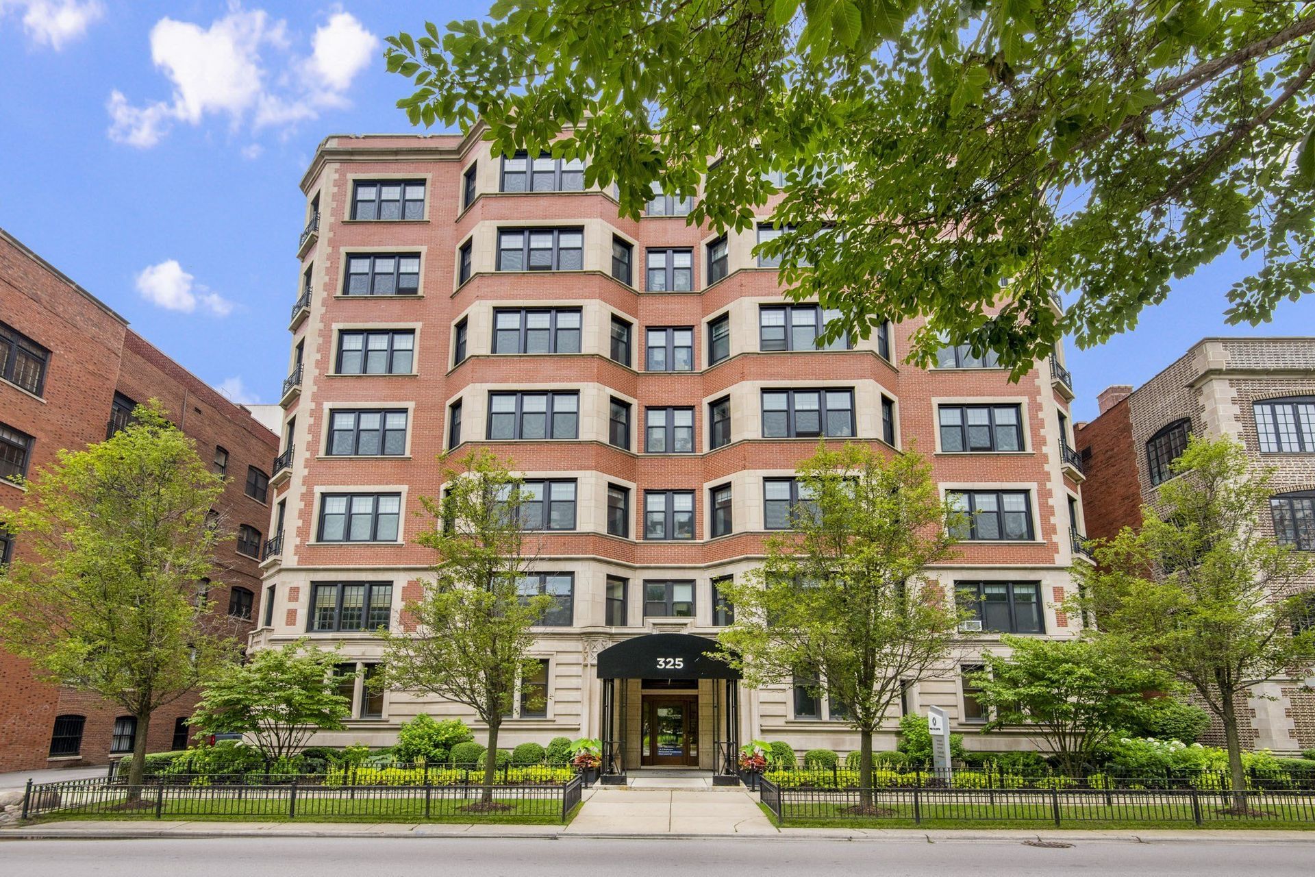 the apartment building has a large brown building with a black door