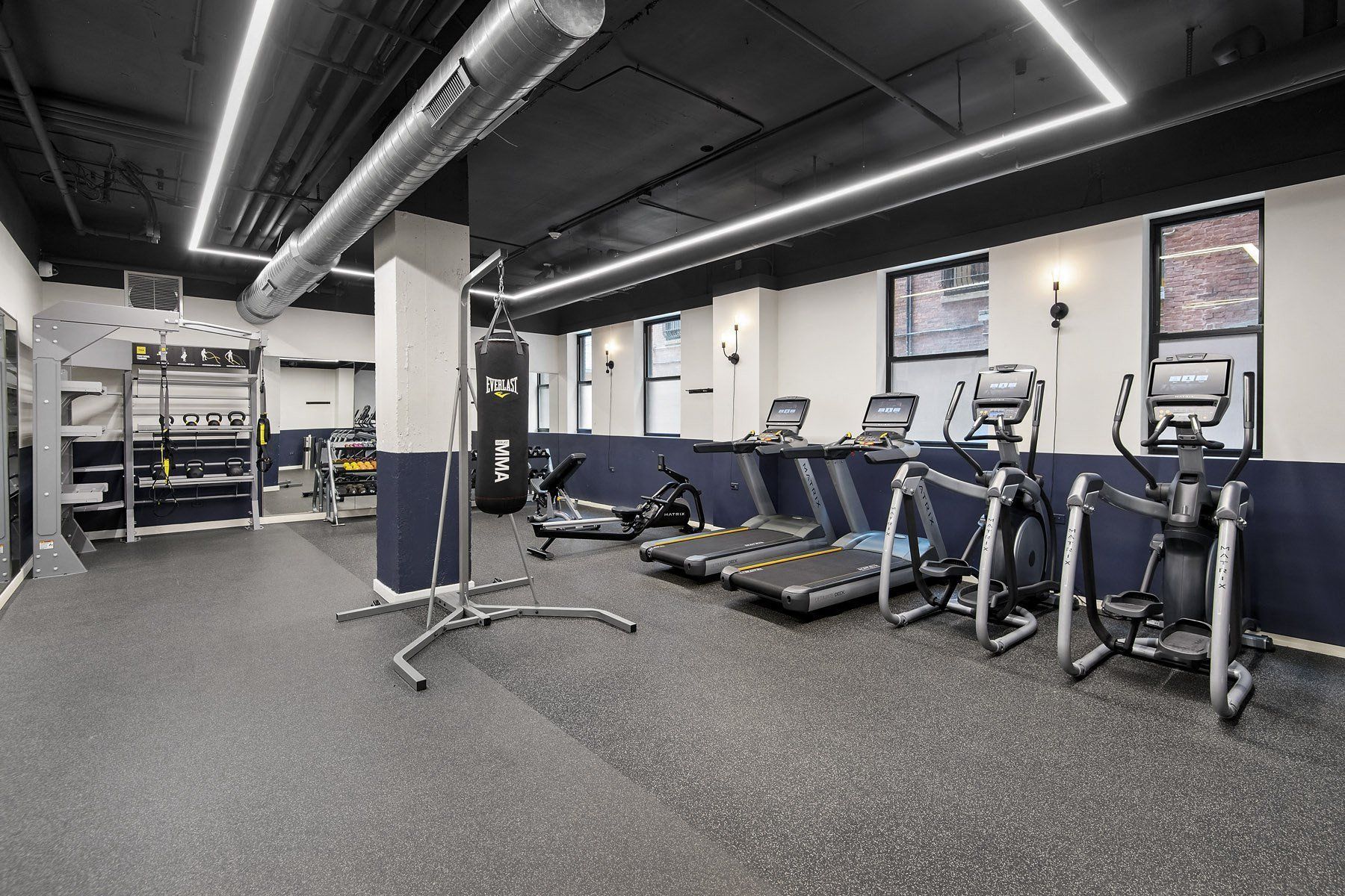 a gym with cardio equipment and weights in a building