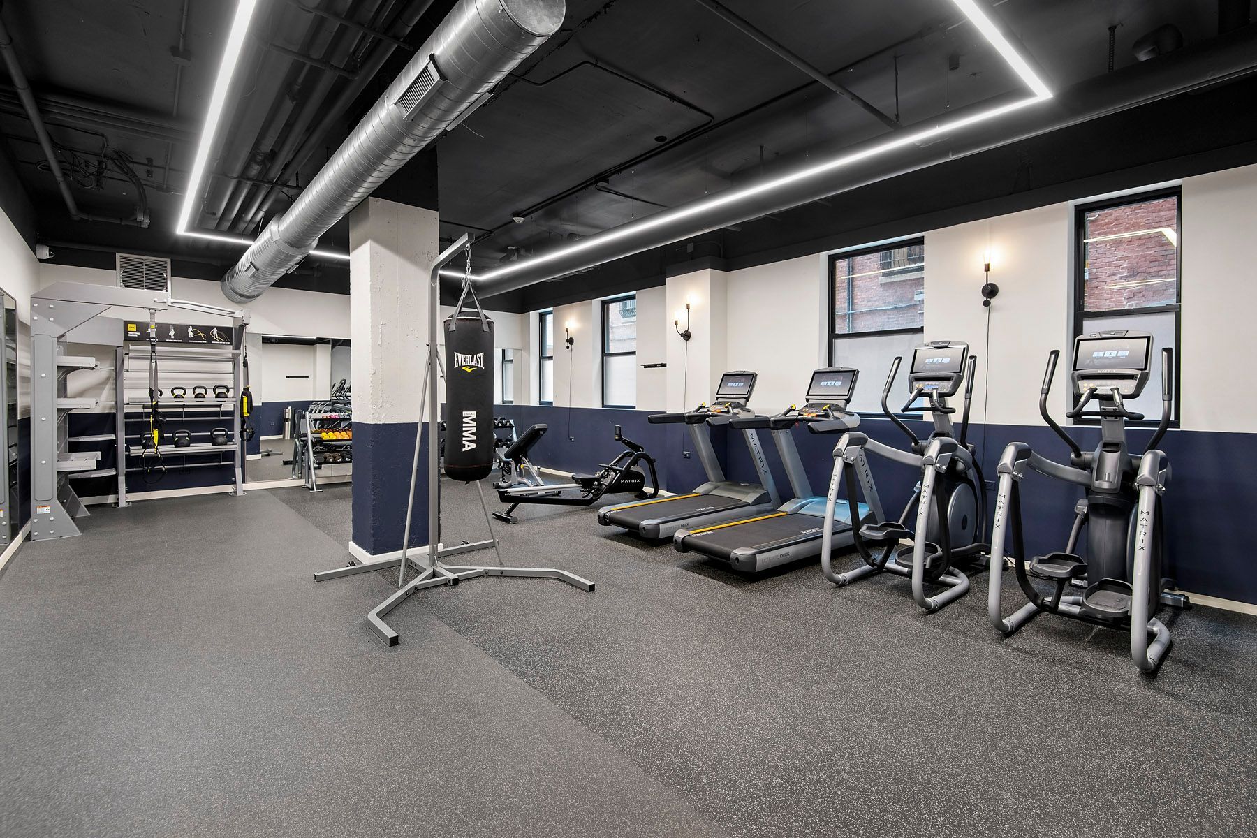 A gym with a lot of treadmills and exercise equipment at Park Fullerton by Reside. 