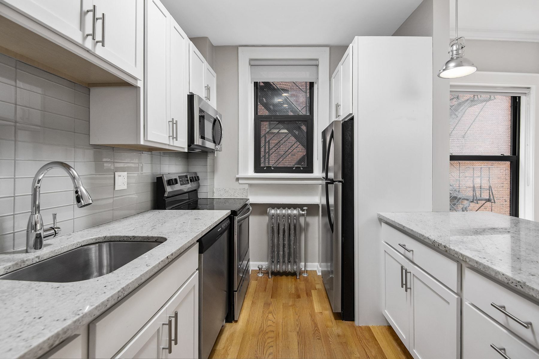 a kitchen with white cabinets and a black refrigerator