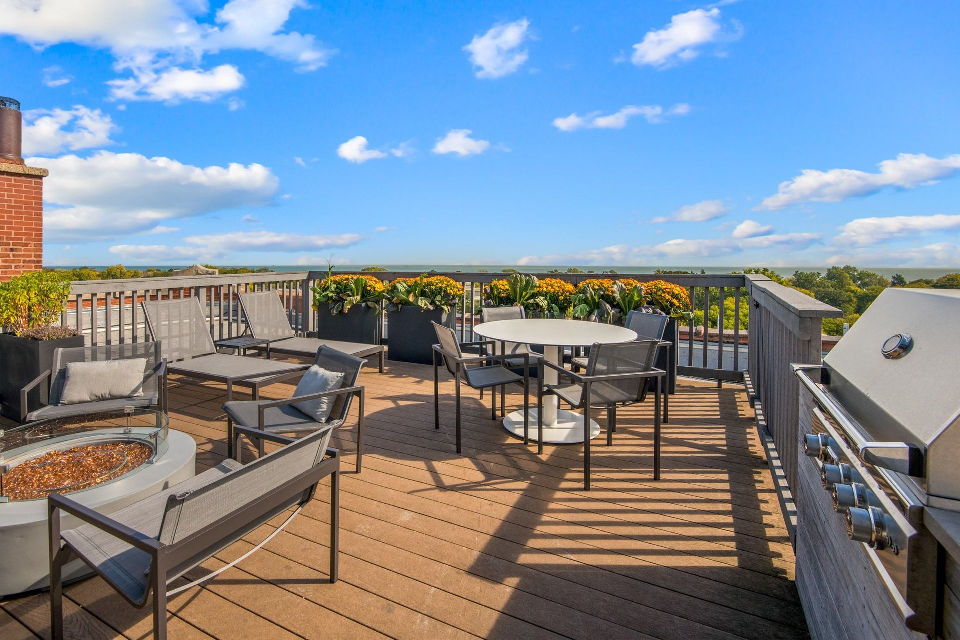 a rooftop patio with tables and chairs and a fire pit