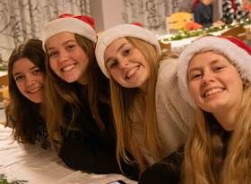 Fire smilende mennesker med nissehuer.